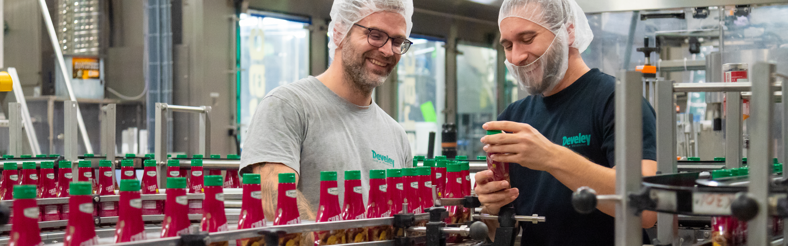 Zwei Produktionsmitarbeiter am Standort Dingolfing kontrollieren die Produktion der Develey Curry Sauce 