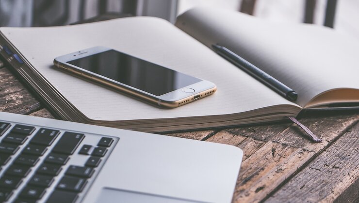 Arbeitsplatz mit Laptop, Smartphone und Notizbuch – Symbolbild für Pressearbeit und Medienservice bei Develey