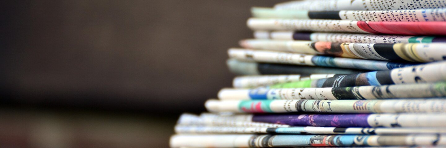 Stapel bunter Zeitungen – Symbolbild für Pressearbeit, Medienberichte und aktuelle Nachrichten über Develey