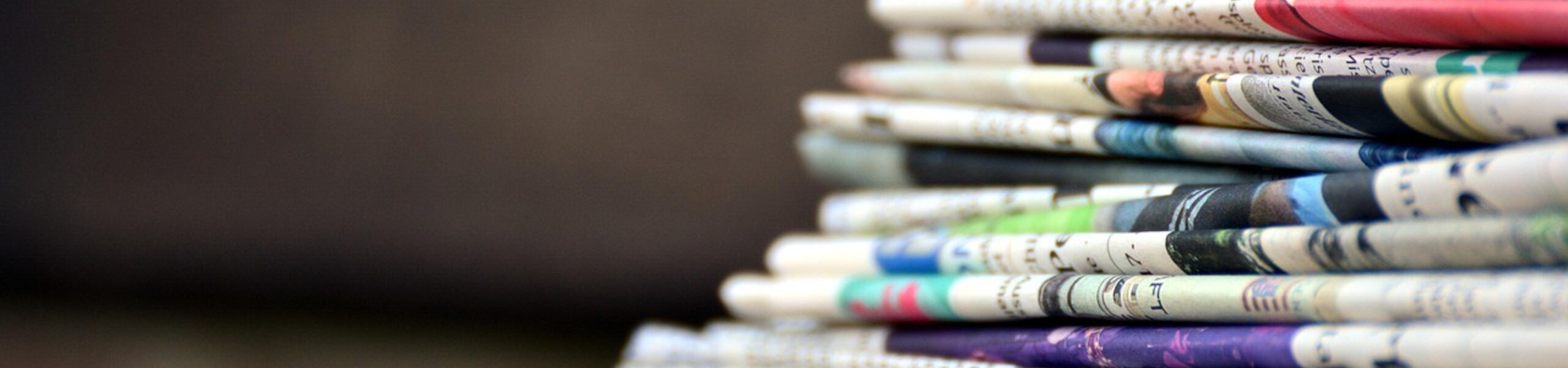 Stapel bunter Zeitungen – Symbolbild für Pressearbeit, Medienberichte und aktuelle Nachrichten über Develey